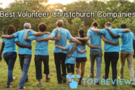 A line of people in matching blue shirts, linking arms, with their backs to the camera. Text reads "Best Volunteer Christchurch Companies. Top Reviews"