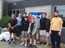 Students stand in a group outside a building with the SPCA logo behind them