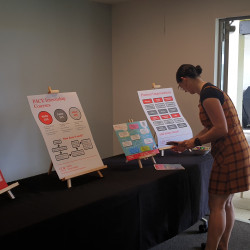 A woman at a table displaying information on the UC PACE Internship programme