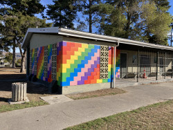 A brightly coloured, painted wall on a building in a park