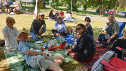 A group of people sitting on the grass, celebrating IVD2024