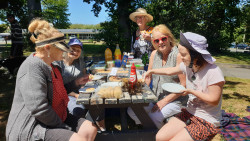 A group of people sitting at a picnic table, celebrating IVD2024