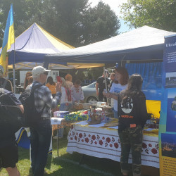 A stand at Culture Galore showcasing Ukraine. A woman at the stand talks to customers