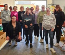 A group of staff from Te Rito Maioha standing in the 0800 Hungry warehouse