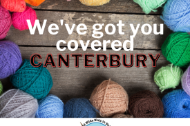 A wooden surface, covered in a ring of colourful balls of yarn. Text in the middle reads "We've got you covered Canterbury".