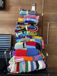 A pile of folded, knitted blankets