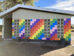 A brightly coloured, painted wall on a building in a park