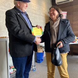 Cathrine, a volunteer knitter, receiving a Certificate of Appreciation