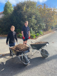 Two St Andrews College students with wheelbarrows full of garden mulch