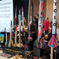 A table displaying model rockets and a sign that reads "Christchurch Rocketeers