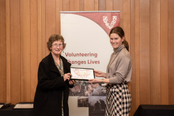 Tricia De Haan, from IHC Volunteer Friendship Programme, receiving her Award on stage