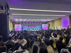 The IAVE conference room, showing tables of attendees and the stage in the background