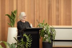 Guest Speaker, Wendy Thompson of Bellyful, stands at the lecturn speaking to the audience