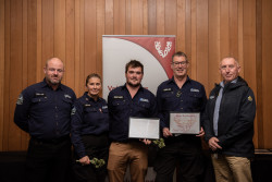 Five members of the Selwyn Response team with their Award, in front of the Volunteering Canterbury banner