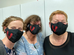 Three VolCan staff members, wearing new fabric face masks bearing the Volunteering Canterbury Logo