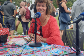 Glenda Martin, sitting at a table wearing radio headphones, at Culture Galore festival.