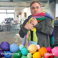 A staff member from Qtopia with their Knit for Purpose blankets