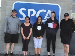 Five people standing in front of a building with the SPCA logo behind them