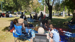 A group of people sitting on the grass, celebrating IVD2024