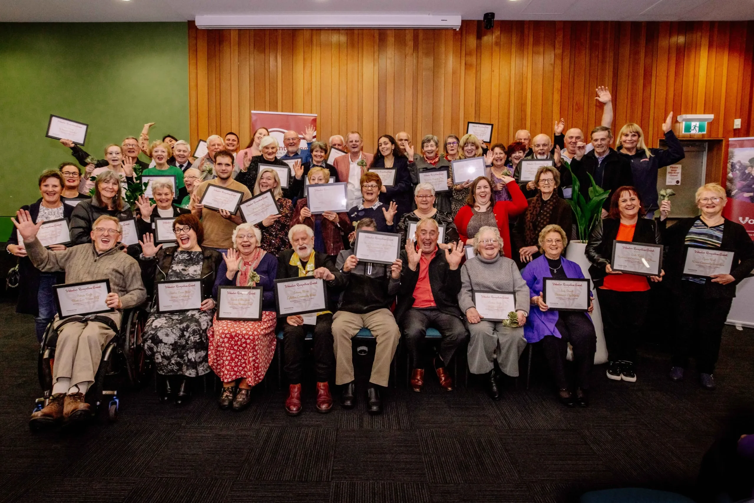 The 2024 Award Recipient Group, sitting and standing in funny poses on stage