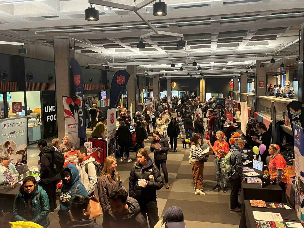 Wide-angle view of the UC Volunteering Expo, showing a large space filled with people and stalls.