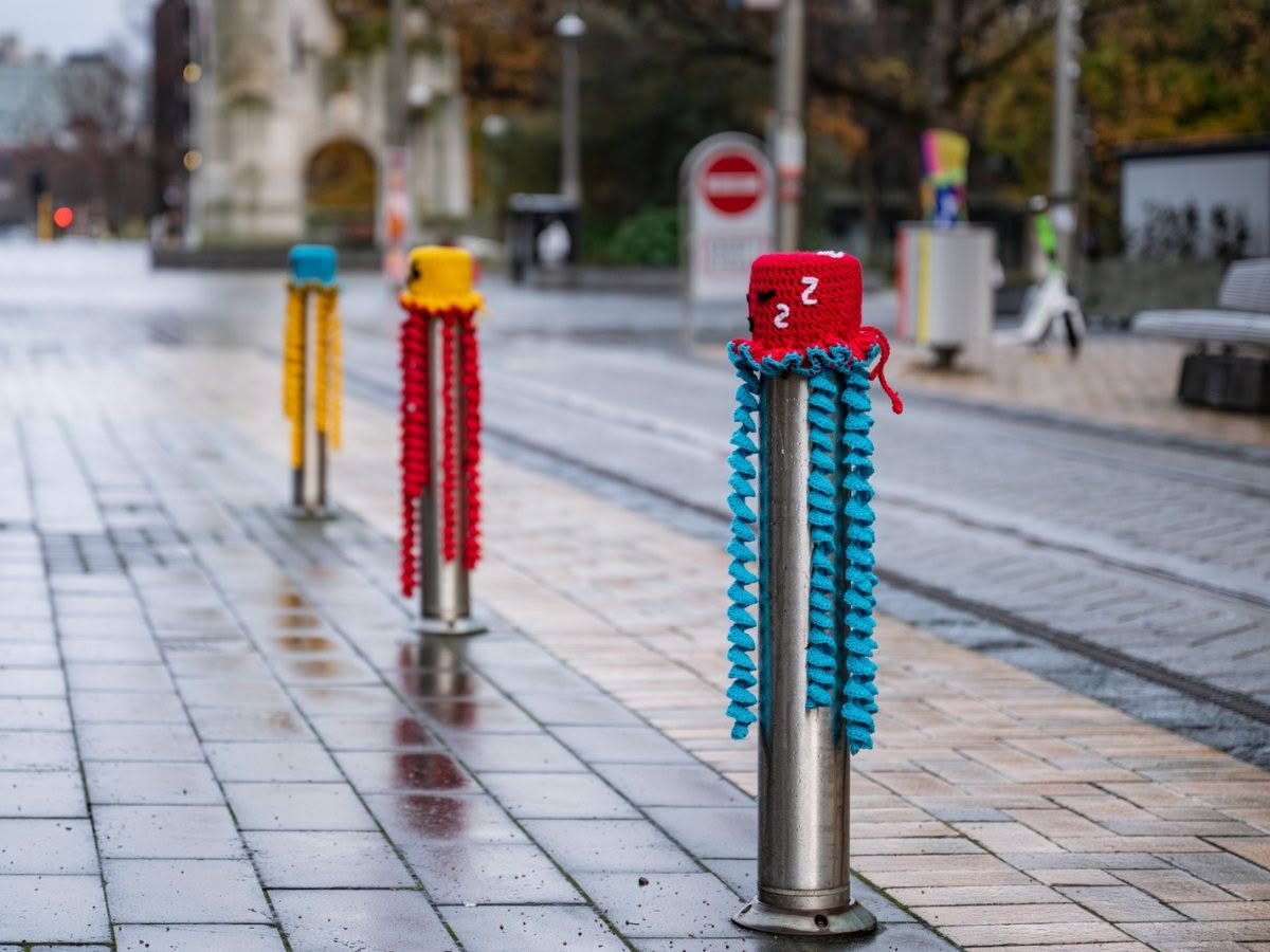 Photo of city bollards, covered in knitting, as part of Yarnarchy.